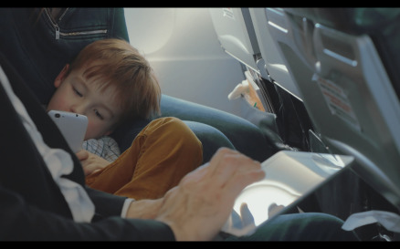 Boy Using Smart Phone And Father With Tablet in Plane - Stock Video