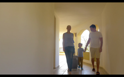 Family with rolling bags in hotel corridor - Stock Video