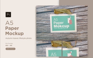 A5 paper mockups with green leaves on wood background