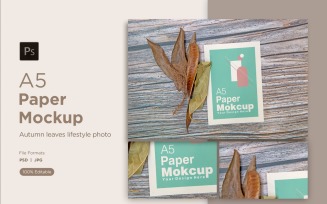 A5 Paper Mockups With Green Leaves and autumn themes leaves on Wooden background