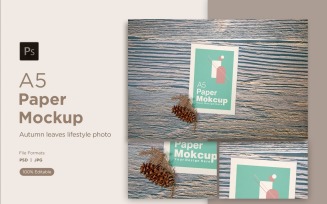 A5 paper mockup with Conifer cone and pinus leaves on wooden background