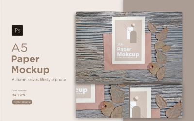 A5 纸贺卡模型与木背景上的干叶。