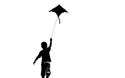 Child joyfully raises hands to fly a playful bat kite in monochrome isolated on white background