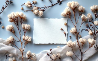 White Paper Held Against White Flowers Card Mockup 180